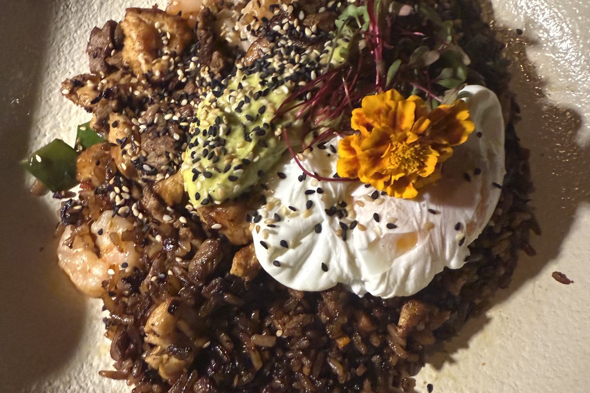 Schale mit Getreide, Avocado, pochiertem Ei und Blüte